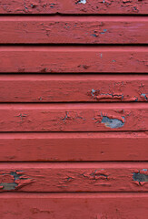 Red paint peeling off from the wooden planks