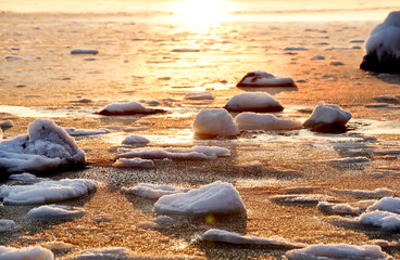 Winter sea in the early morning. frozen water and stones at dawn. Odessa. Ukraine
