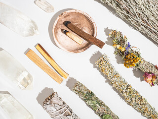 Items for spiritual cleansing - sage and aromatic herbs bundles, palo santo incense sticks and quartz crystals - obrazy, fototapety, plakaty