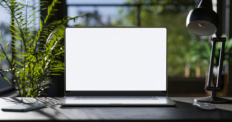 Laptop with blank frameless screen mockup template on the table in industrial office loft interior...