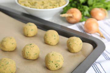 Raw falafel balls on baking sheet, closeup