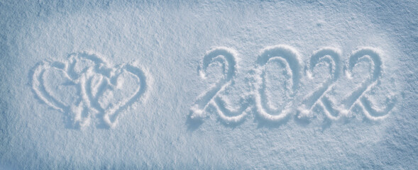 The numbers 2022 are written on snow. New Year's date concept.
