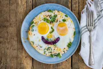 sunny side up eggs with smiling face shape on wooden table for breakfast