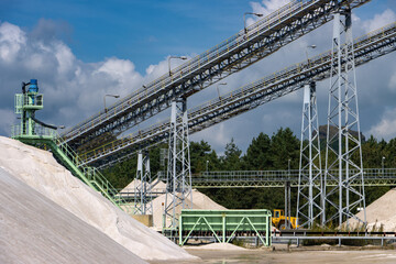 Sand pit with piles of sand and technical equipment incl. conveyor belts