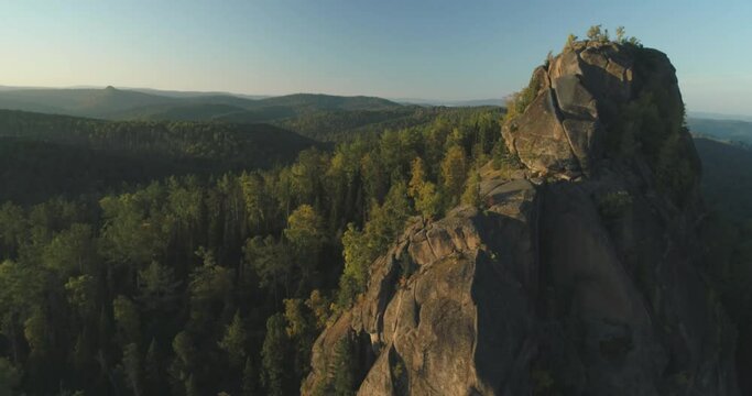 Flying over the trees in the forest overlooking the high cliff. High quality 4k footage