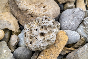 Stones with rock erosion holes at beach in Ireland