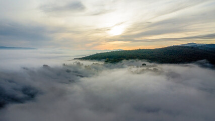 Drone shot of the landscape in Umbria in Italy. Sunrise with fog in the valley. High quality photo