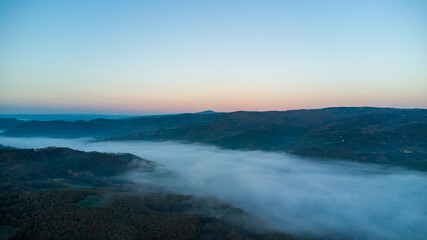 Drone shot of the landscape in Umbria in Italy. Sunrise with fog in the valley. High quality photo