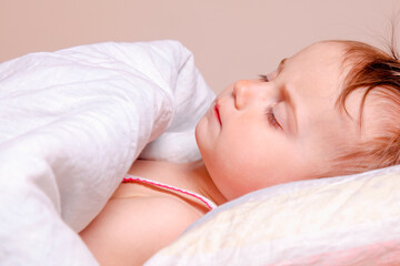 Fototapeta na wymiar Carefree sleep and children's happy dreams. Portrait of adorable cute baby girl sleeping on king bed.