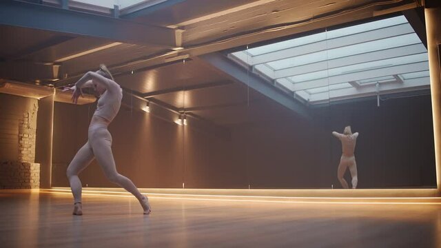 Cinematic, young female is doing yoga in a mirror room with light lines, flexible female performs a beautiful dance with yoga elements, stretching dance.