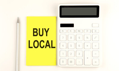 text BUY LOCAL on yellow sticker, next to pen and calculator