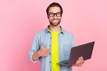 Photo of young man boss chief show thumb-up approve good quality use laptop isolated over pink...