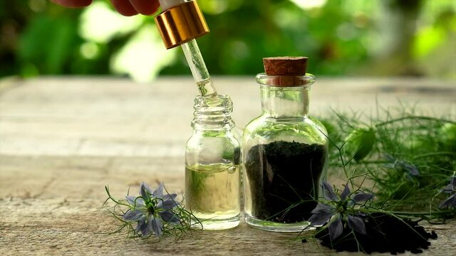 Black cumin oil in a bottle. Selective focus.