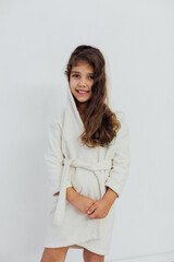 a little curly girl in a white house coat