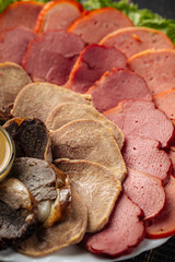 Closeup on assorted sliced smoked meat platter appetizer