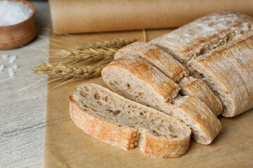 Fresh crispy ciabatta on white wooden table, closeup