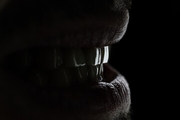 artistic dental macro photography of a smile lips and teeth with nice lights on black background