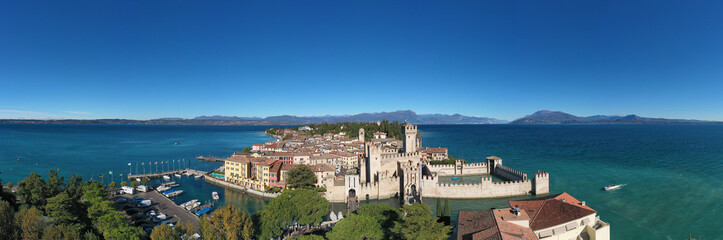 Fototapeta na wymiar Sirmione aerial view. Autumn in Sirmione. Top view, historic center of the Sirmione peninsula, lake garda. Lake Garda, Sirmione, Italy. Aerial panorama of Sirmione.