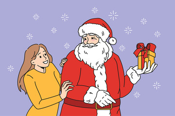 Preparation for Christmas holidays concept. Positive young woman standing and hugging Santa holding present present in box with ribbon vector illustration 