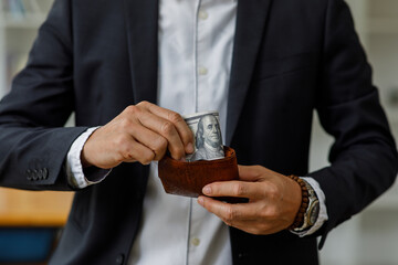 Businessman Hand holding US dollars, American bills money dollars in hand. Saving money and investing or Bribery and corruption concept.