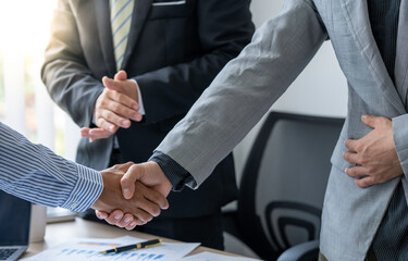 businesspeople are shaking their hands after signing a contract at the meeting, close-up. Business communication concept