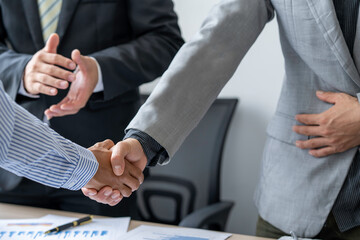 Obraz premium businesspeople are shaking their hands after signing a contract at the meeting, close-up. Business communication concept