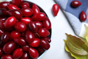 Fresh ripe dogwood berries, leaves and napkin on light grey table, flat lay