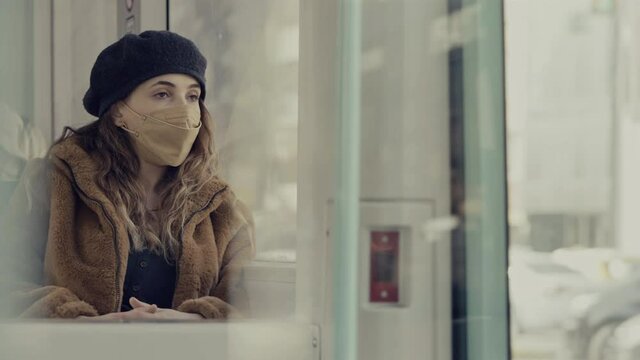 Young woman sitting on a bus with mask	