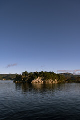 Landscape of trees on rocky islands in Lusefjord. Fjord cruise. Tourism in Norway. Beautiful nature on sunny day.