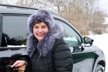 Woman  in winter gets into the car