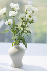 white porcelain vase with small chrysanthemum flowers.