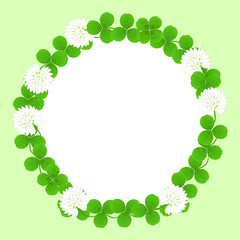 薄緑色の背景にシロツメクサの花と葉で作られたリースの円形フレーム