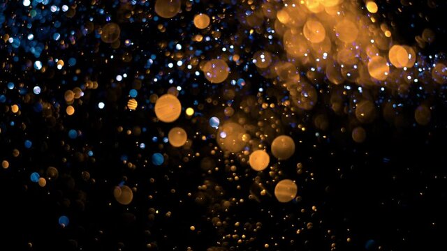 4K Glitter Sparkling Magic light. Shining gold Dust particles Trail Crossing sparkles on black background 4K. Birthday, Anniversary, new year, event, Christmas, Festival, Diwali. Golden Glitter