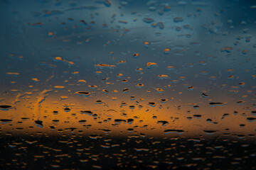Raindrops on the glass at sunset. Natural abstract background. The concept of rain. - 474892972