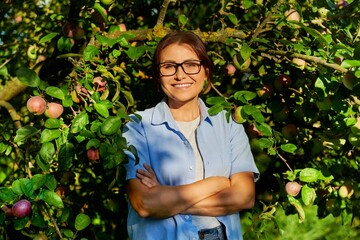 Outdoor portrait of a middle aged woman in an apple orchard.
