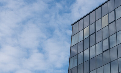 Skyscrapper building on a blue sky background with steel and glass.