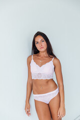 Fototapeta premium beautiful woman in pink lingerie in a white room