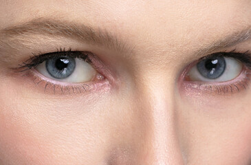 Blue eyes of a girl close up. Part of the face.