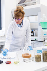 Woman in CBD laboratory writing results with pen on paper