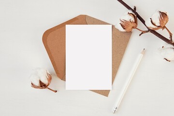 Vertical A6 size card mockup with brown envelope, flat lay composition on white background with...