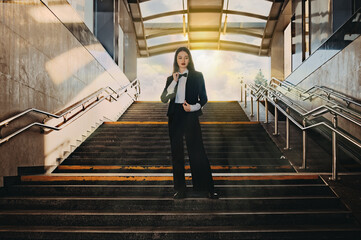 portrait of a young girl in a suit in an underpass on the stairs