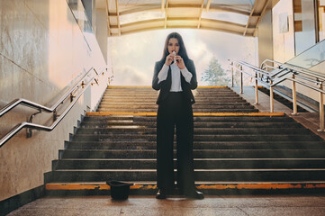 girl musician plays the flute. woman in a suit and bow tie in a top hat in an underpass