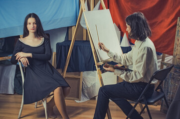 young artist paints a portrait of a beautiful girl