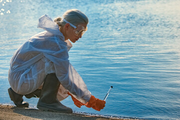 checking the water by a specialist in a protective suit and mask - obrazy, fototapety, plakaty
