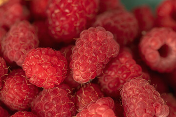Ripe red raspberries on a plate.