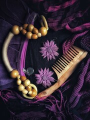 violet still life with bag, scarf, comb and earrings with selective focus