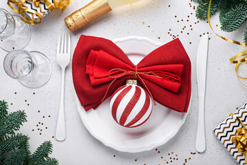 Christmas table setting white color with silverware, napkin red color, Christmas balls, champagne, glasses on white background for xmas greetings. Mock up.