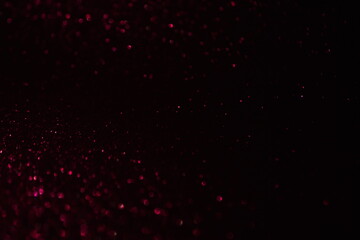 Glittering festive red and black background. Concept of New Year celebration. defocused blurred background
