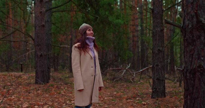 Beautiful woman stands in a coniferous forest and breathes clean air. Environmentally friendly natural environment, human health. Fresh air in the coniferous forest. 4k, ProRes