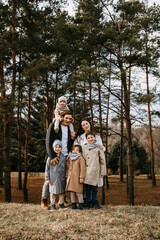 Big family walking outdoors in a forest. Family spending fun time together on an autumn day.